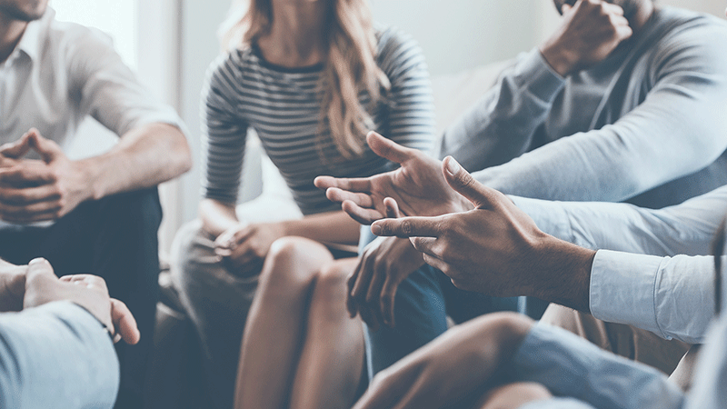 Close up of Multi-ethnic group of people talking in a circle. Therapy